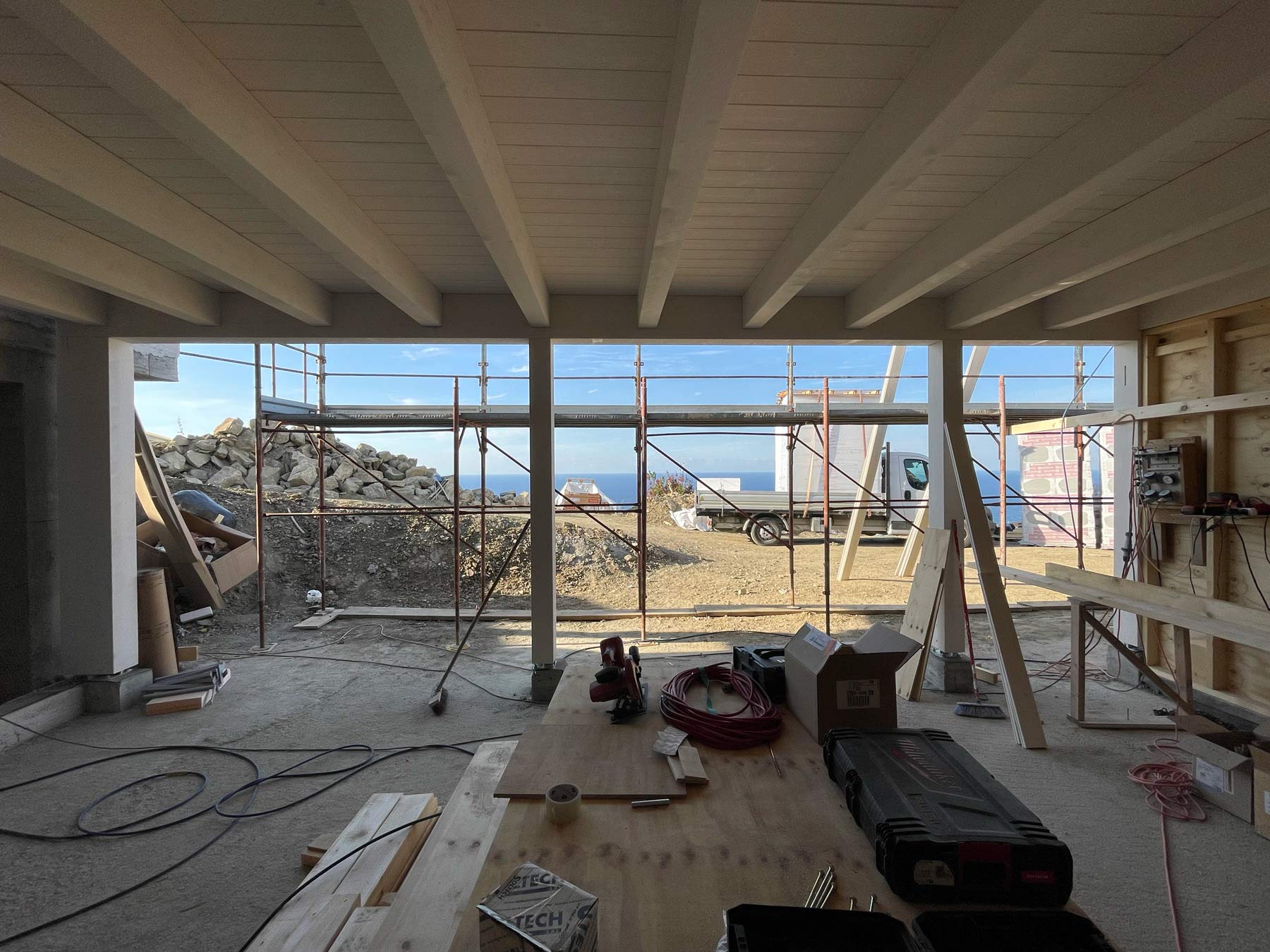 25/09/2026: Il solaio procede veloce! Cantiere di una casa a struttura in legno con travi sbiancate sul soffitto e vista sul mare di Sanremo